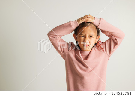 Asian portrait young kid girl standing angry and mad raising fist frustrated and furious while shouting with anger isolated, studio shot on white background, kindergarten child not happy 124521781