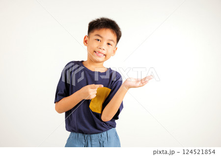 Asian happy portrait cute young boy smile presenting product holding something on palm away side, studio shot isolated on white background with copy space, primary child show hand gesture 124521854