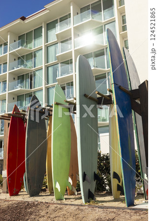 Many Surfboards On Stand Outdoor. Colorful Soft Foam And Wooden Construction Classic Surfboard Longboard Or Malibu. Vertical. Sunny Day, Seashore Or Ocean. Nobody. No People. 124521865