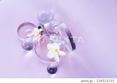 A serene spa background showcasing aloe serum, decorative glass spheres, and fresh flowers. 124523133