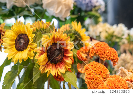 Colorful flowers in vases and bouquets are arranged neatly inside a florist shop. The natural light and variety of blooms create a fresh, elegant atmosphere. Colorful flowers in vases and bouquets are arranged neatly inside a florist shop. The natural light and variety of blooms create a fresh, elegant atmosphere. 124523896