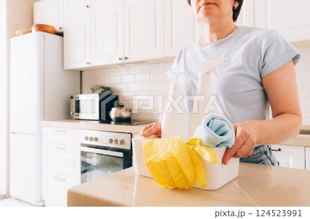 Mature woman in kitchen with cleaning products, cleaning concept, cleaning services Mature woman in kitchen with cleaning products, cleaning concept, cleaning services 124523991