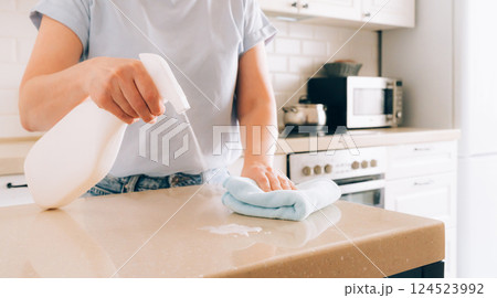 Female adult cleaning kitchen counter with spray bottle and cloth Female adult cleaning kitchen counter with spray bottle and cloth 124523992