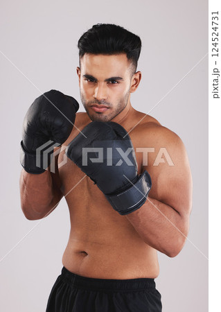 Boxing gloves, portrait and man training in sports fight, challenge or mma competition on studio background. Strong, focus and fitness guy, professional boxer champion and bodybuilder, fist and power 124524731