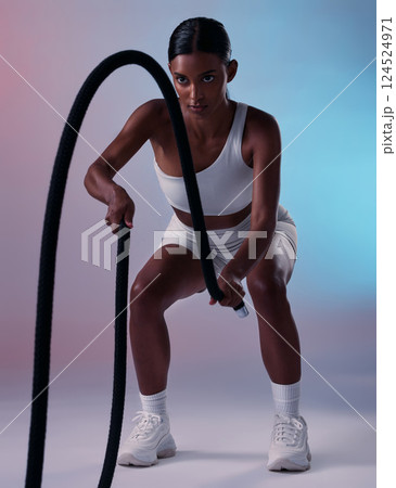 Girl, fitness and rope training exercise for cardio, muscle and endurance practice with color studio background. Focus, health and power of Indian woman training with gym wellness workout gear. 124524971
