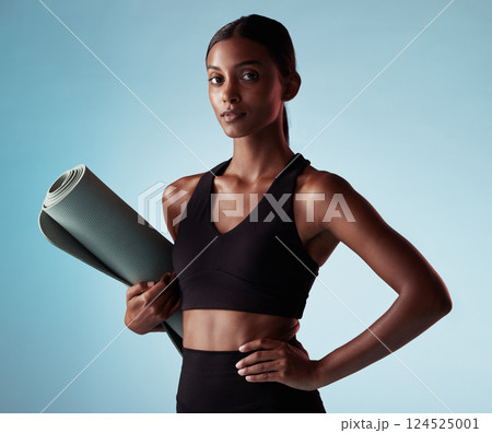 Woman, fitness and yoga model in health, wellness or spiritual exercise posing against a blue studio background. Portrait of healthy isolated female pose in sports training for mind, body and spirit 124525001