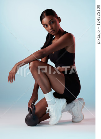 Fitness, kettlebell and exercise woman against a studio background with body workout, exercise and motivation. Wellness, sports training and healthy lady, strong and athlete cardio with exercising 124525109