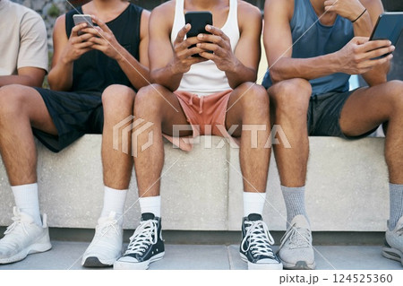 Digital devices, group and young men on social media, browse internet and reading online in city being trendy together. Smartphones, edgy and boys scroll apps, casual and outdoor relax in summer. 124525360