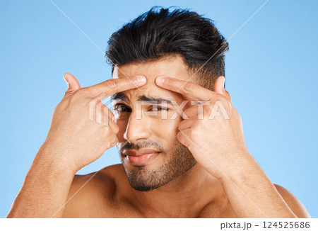 Skincare, confused and portrait of acne man with hands on face feeling pimple with anxiety, doubt and stress. Model in studio analyzing skin with facial aesthetic problem on blue background. Skincare, confused and portrait of acne man with hands on face feeling pimple with anxiety, doubt and stress. Model in studio analyzing skin with facial aesthetic problem on blue background. 124525686