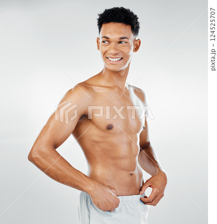 Skincare, cleaning and man in towel after shower in studio for wellness, beauty and grooming against white background. Skin, bodycare and bathroom hygiene with guy model confident, muscular and happy 124525707