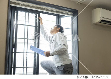 出窓のサッシの点検をする作業員 124525809