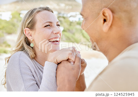 Beach, holding hands and man propose to woman on holiday by sea, happy and smiling together. Affection, romance and multicultural couple by ocean, enjoying vacation and bonding on weekend in summer 124525945