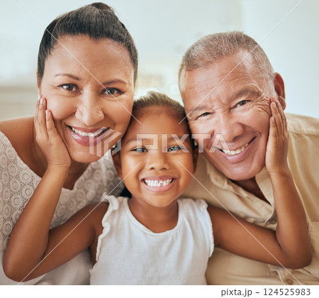 Family, portrait and face of girl with grandparents relax, bond and having fun in a living room, happy and content. Happy family, smile and child hugging senior man and woman, enjoy quality time 124525983