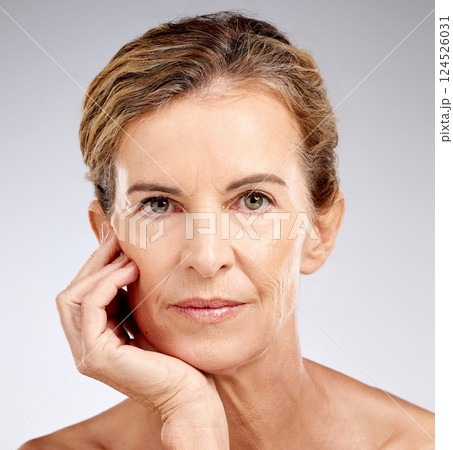 Face, beauty and skincare with a mature woman posing for antiaging treatment in studio on a gray background. Portrait, wellness and wrinkles with a model female inside to promote a natural product 124526031