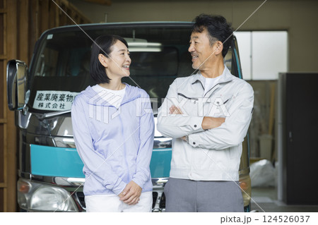 トラックの前で立つ工務店を営む夫婦 124526037