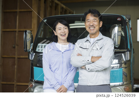 トラックの前で立つ工務店を営む夫婦 124526039