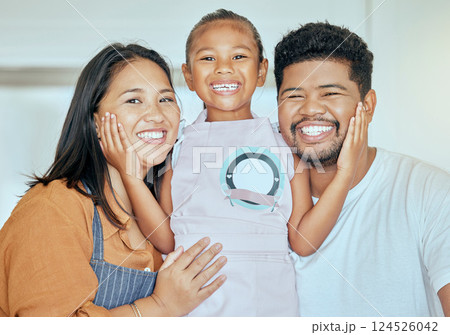 Family, baking and girl hug of a mother, father and child ready for cooking in a home kitchen. Portrait of a mom, dad and kid together with love looking forward to food learning activity at a house 124526042