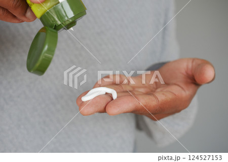 Applying cream to hand for skincare routine 124527153