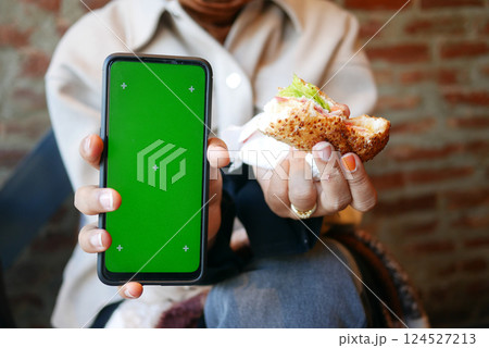 Enjoying a meal while capturing moments on a smartphone 124527213