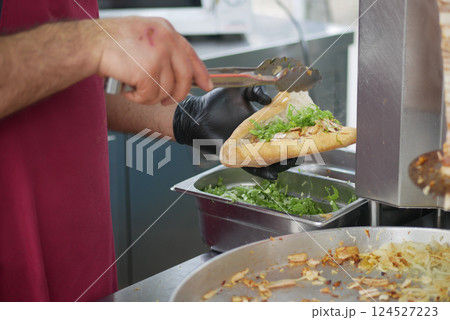 Street Food Vendor Preparing Delicious Sandwich Street Food Vendor Preparing Delicious Sandwich 124527223