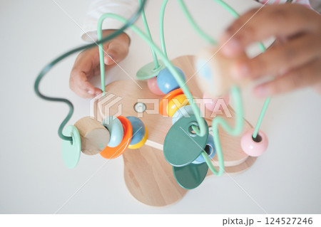 Hands engaged in colorful wooden bead activity for young children Hands engaged in colorful wooden bead activity for young children 124527246