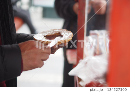 Person preparing a snack with a spread at a street cart Person preparing a snack with a spread at a street cart 124527300