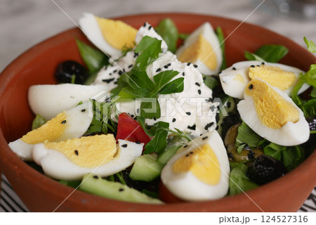 Fresh salad with eggs and herbs in a rustic bowl on a table Fresh salad with eggs and herbs in a rustic bowl on a table 124527316