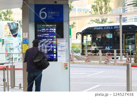 バス停で時刻、行先を確認する乗客 124527438