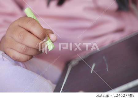 Child drawing with chalk on a small blackboard at home Child drawing with chalk on a small blackboard at home 124527499