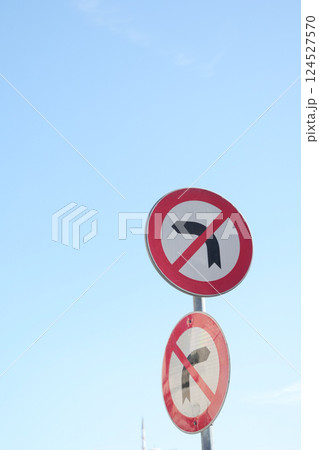 No U turn signs against a clear blue sky in a traffic area 124527570