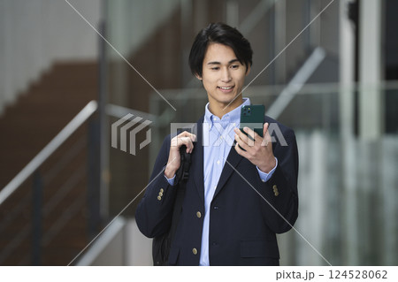 スマートフォンの画面を見る若いビジネスマン 124528062