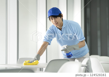 カメラ目線で笑顔の若い男性クリーニングスタッフ カメラ目線で笑顔の若い男性クリーニングスタッフ 124528161