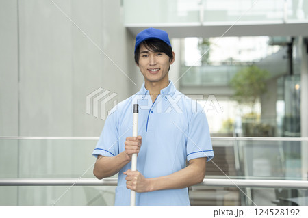 カメラ目線で笑顔の若い男性クリーニングスタッフ 124528192