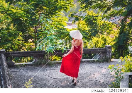back of a young woman tourist in traditional Vietnamese hat Non La in Vietnam on travel to Asia 124529144