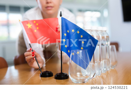 Female secretary places flags of the European Union and China flag on the table before negotiations of top political figures Female secretary places flags of the European Union and China flag on the table before negotiations of top political figures 124530221