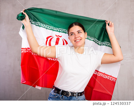 Pretty young girl holding Iran flag in her hands Pretty young girl holding Iran flag in her hands 124530337
