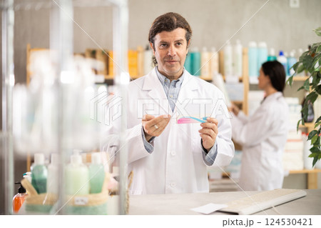 Adult man pharmacist offering pills Adult man pharmacist offering pills 124530421
