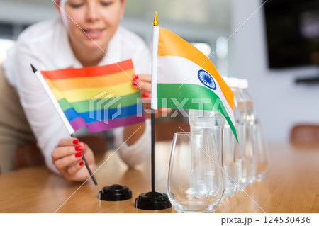 Unrecognizable girl sets midget flags of India and LGBT before international negotiations Unrecognizable girl sets midget flags of India and LGBT before international negotiations 124530436