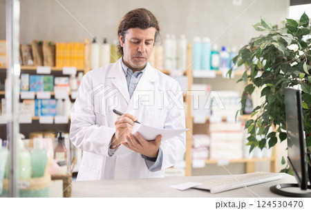 Man pharmacist makes restock, uses paper carrier of information 124530470