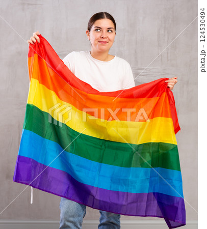 Happy girl stands with flag of LGBT. Isolated on gray background 124530494
