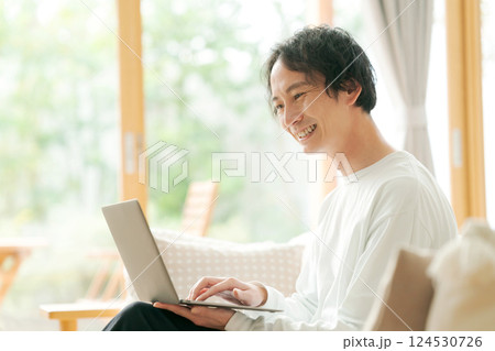 リビングでパソコンを使う男性 124530726