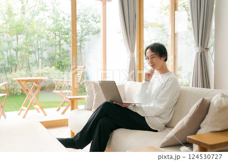 リビングでパソコンを使う男性 124530727