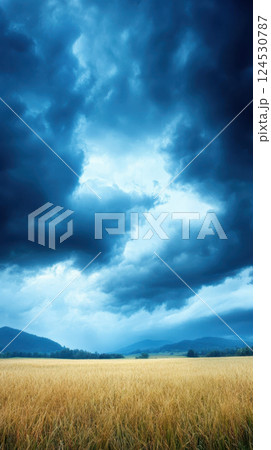 Dramatic storm clouds loom over golden field, creating striking contrast 124530787
