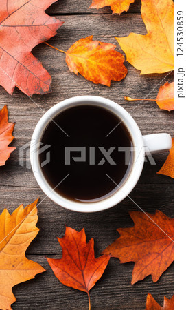 coffee cup surrounded by vibrant autumn leaves on wooden table 124530859