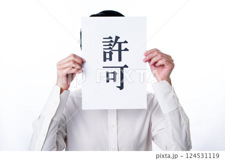 許可と書かれたパネルを掲げ気持ちを伝える人物 124531119