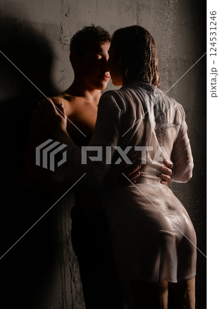 Passionate embrace between a couple in the rain at night 124531246