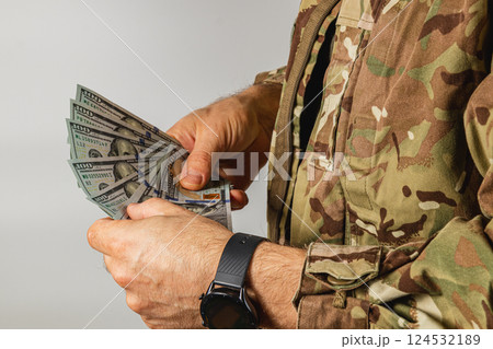 Soldier counting cash in military uniform indoors Soldier counting cash in military uniform indoors 124532189