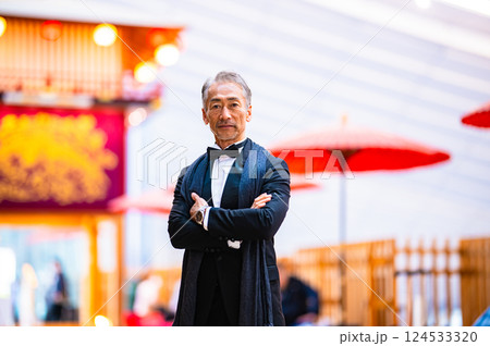 タキシードを着た両手を広げた、実業家の男性とお祭りのやぐら 124533320
