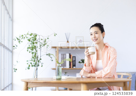 リビングでコーヒーを飲んでいる女性 リビングでコーヒーを飲んでいる女性 124533839