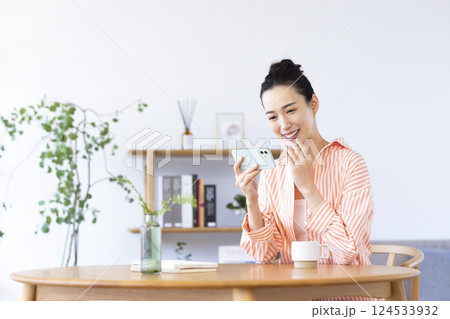 リビングでスマホを見ている女性 124533932